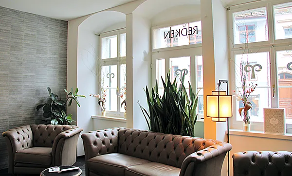 Wartebereich mit Sofas und grossen Fenstern