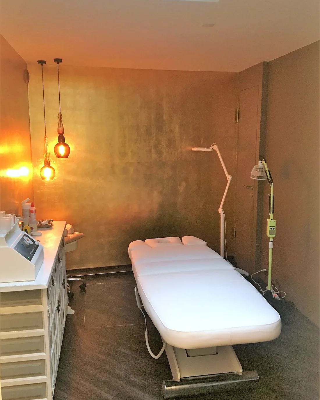 Behandlungsraum der Naturheilpraxis Annette Walter mit goldener Wand und Liege